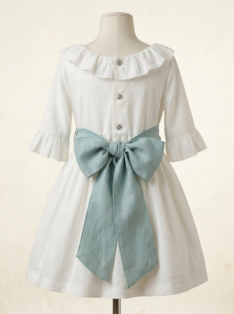 Vestido hilo con volante en cuello y mangas con fajin lino y broche flores